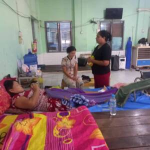 Chaplain praying for leprosy patient