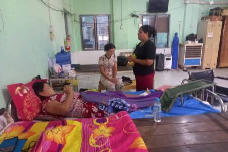 Chaplain praying for leprosy patient