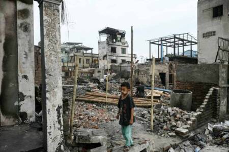 Boy standing among earthquake debris in Mandalay