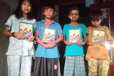 Children of lepers with Bible stories book